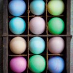 A crate filled with an assortment of dyed easter eggs.