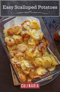 A glass casserole dish filled with golden brown easy scalloped potatoes
