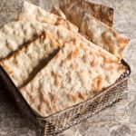 Sheets of homemade matzoh in a metal basket.