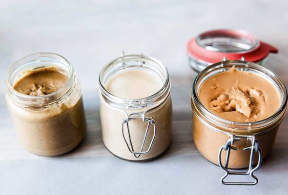 Three jars of homemade nut butter made with different nuts.