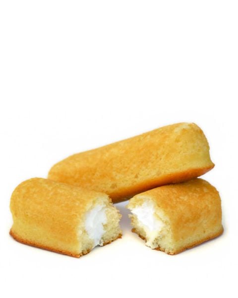 Two homemade Twinkies, with one cut in half and the other resting on top of a cut half.