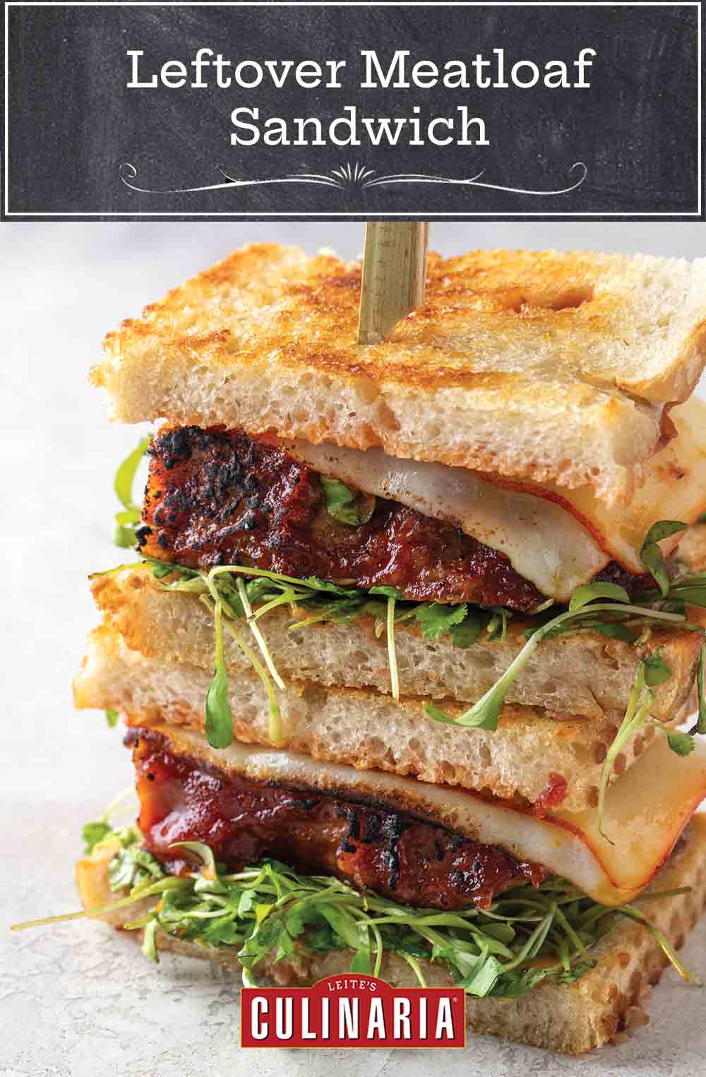 Two halves of a leftover meatloaf sandwich stacked on top of each other and held together with a wooden skewer.