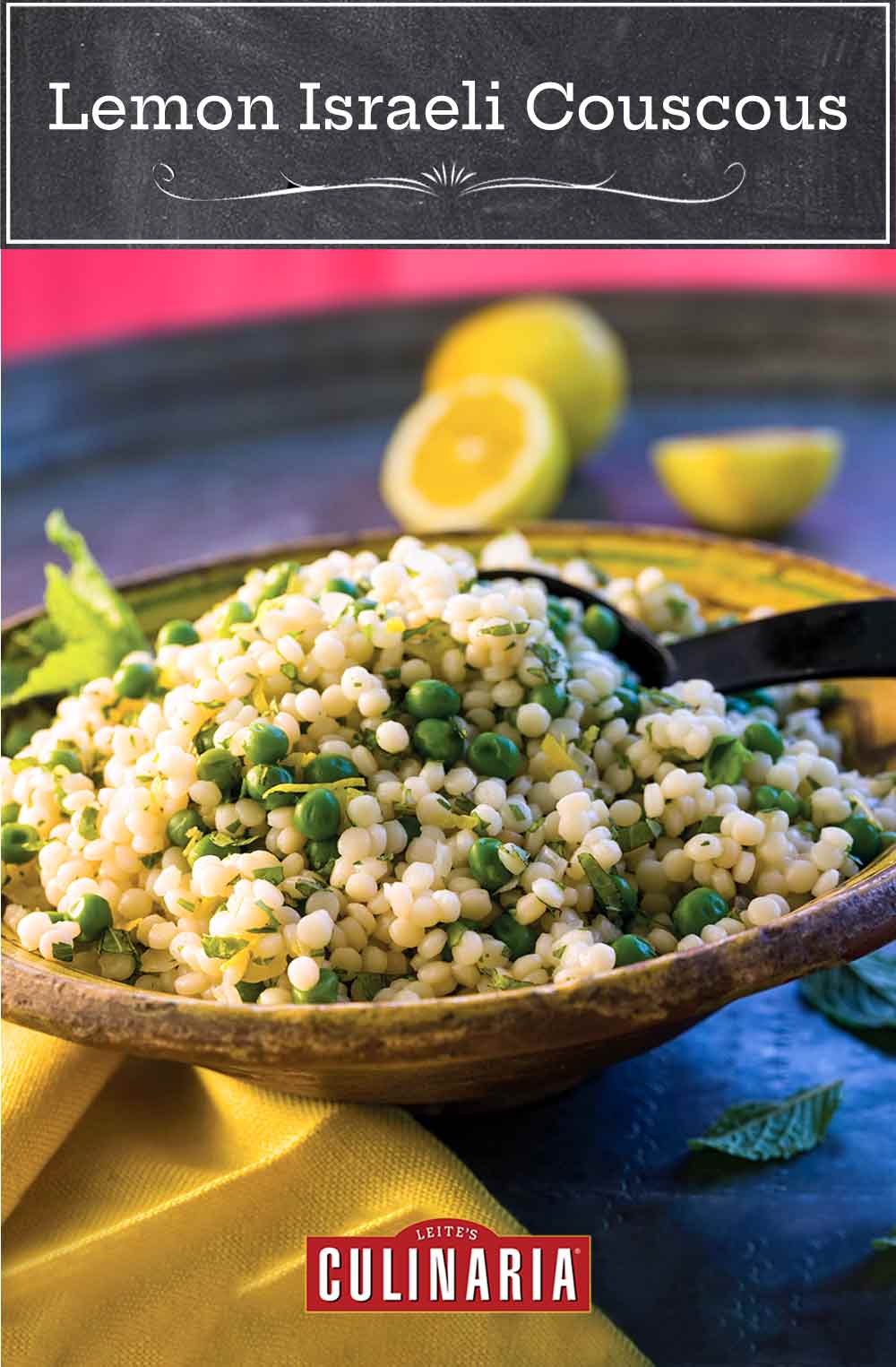 A wooden bowl filled with lemon Israeli couscous with a serving spoon inside and some lemon halves in the background.