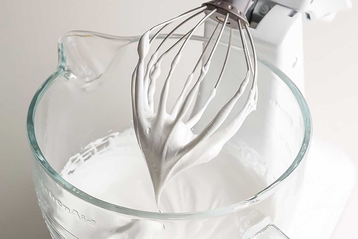 Meringue on a whisk, as illustration of the difference between French, Italian, and Swiss meringues.