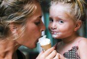 A mother and daughter sharing a mint chocolate chunk ice cream cone.