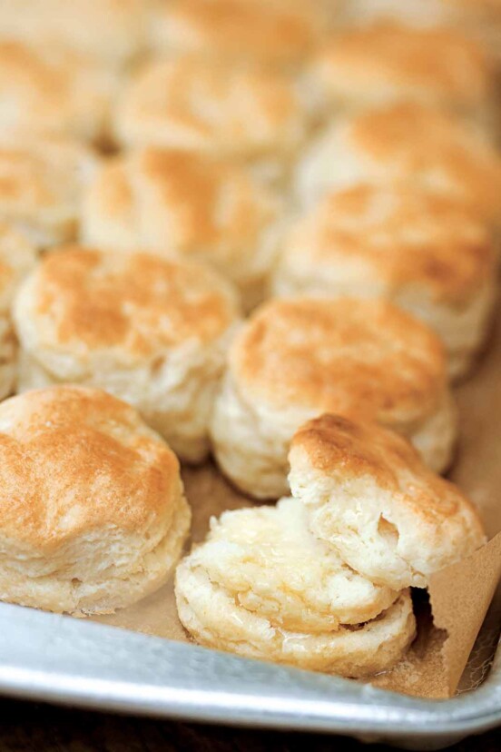 A rimmed baking sheet with rows of Southern buttermilk biscuits.