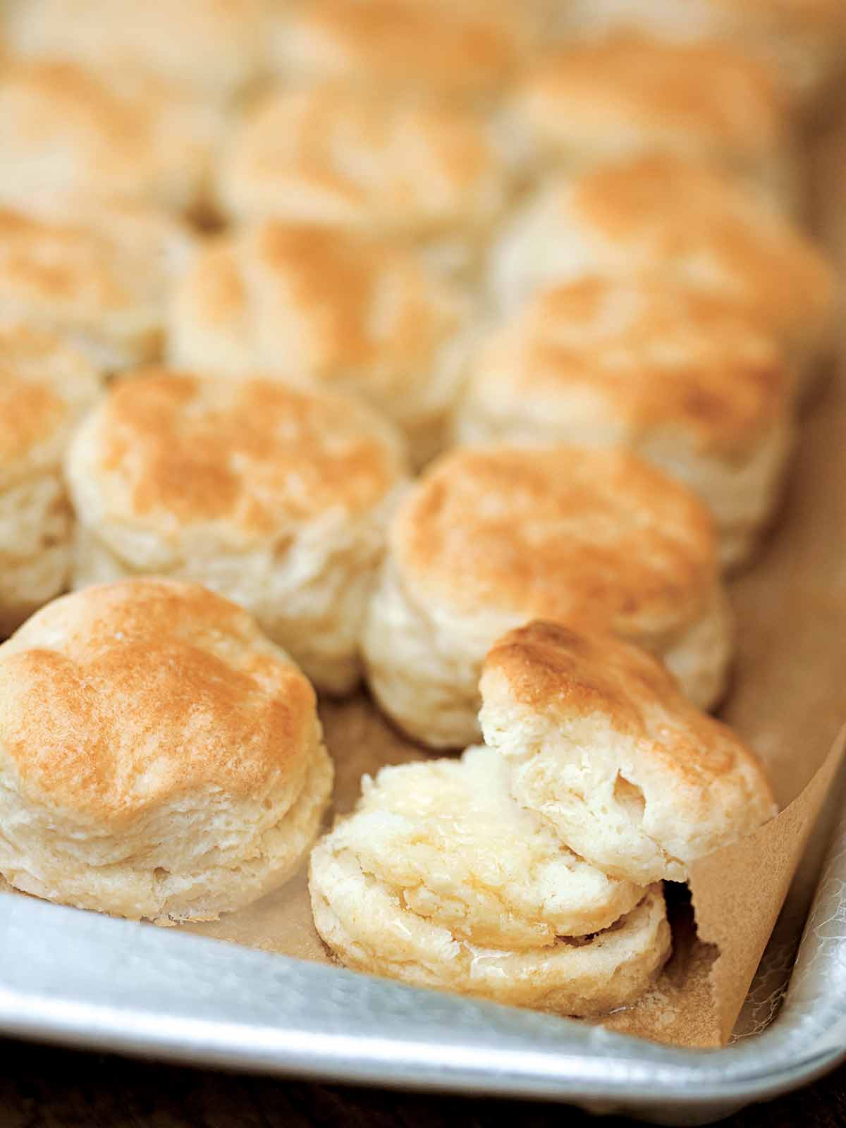 A rimmed baking sheet with rows of Southern buttermilk biscuits.