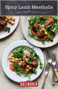 Three plates topped with spicy lamb meatballs, chickpeas, and arugula with three forks and two knives on the side.