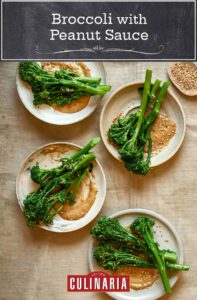 Four plates topped with broccoli with peanut sauce and a small dish of sesame seeds on the side.