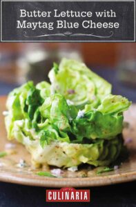 A salad of butter lettuce with maytag blue cheese on a brown plate.