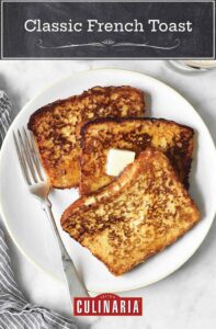 Three slices of classic French toast on a white plate with a pat of butter on top and a fork on the side.