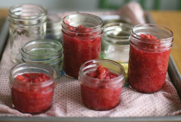 A table with four canning jars filled with easy rhubarb jam