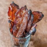 Several slices of maple sriracha bacon in a glass.