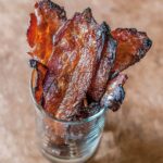 Several slices of maple sriracha bacon in a glass.