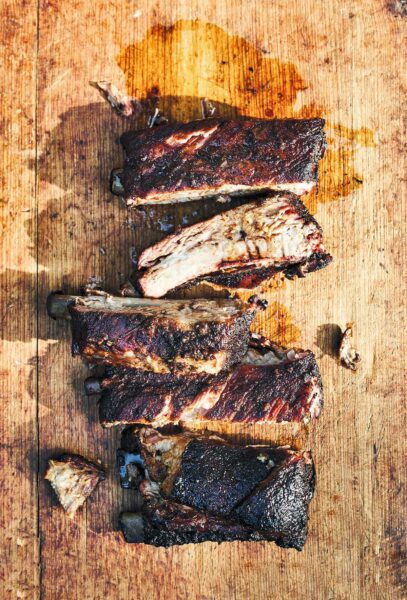 Five cut Memphis style ribs on a wooden board.