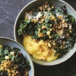 Two bowls of polenta with greens, topped with grated Parmesan and crispy bread crumbs.