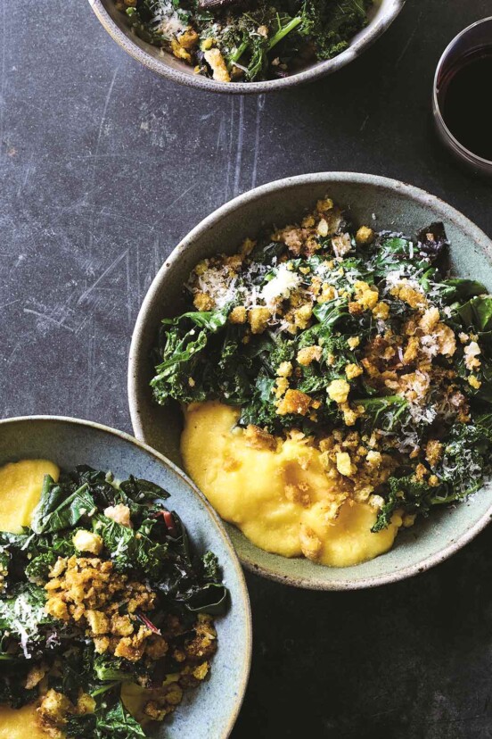 Two bowls of polenta with greens, topped with grated Parmesan and crispy bread crumbs.