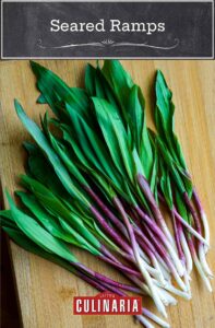 A pile of fresh ramps on a wooden cutting board in preparation to be made into seared ramps.