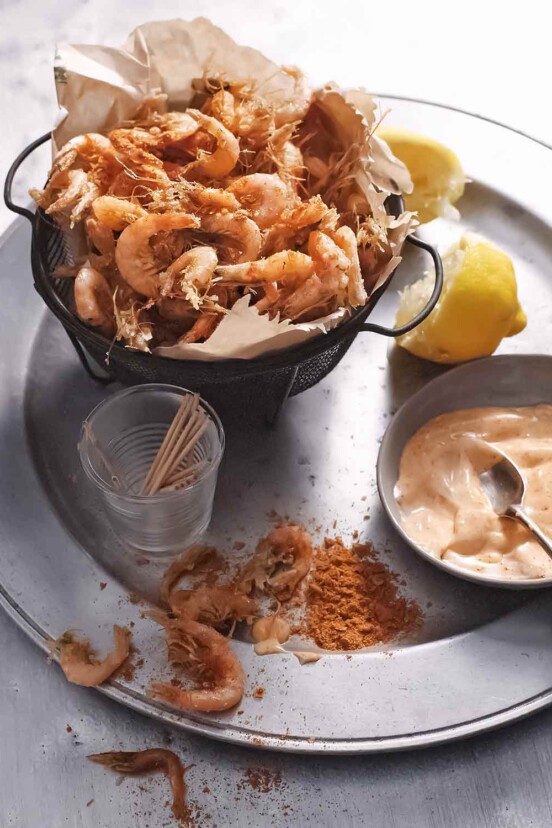 A basket of spiced shrimp with paprika mayonnaise on the side.