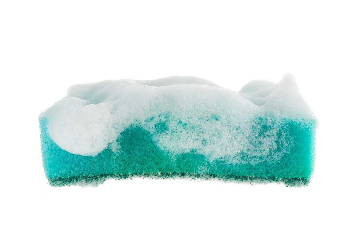 A sponge with soap suds on it.