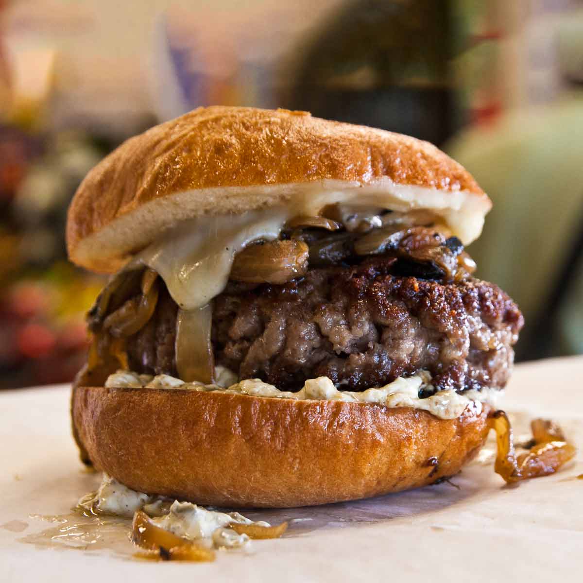A best burger tucked inside a burger bun, topped with mushrooms, cheese, and caramelized onion.