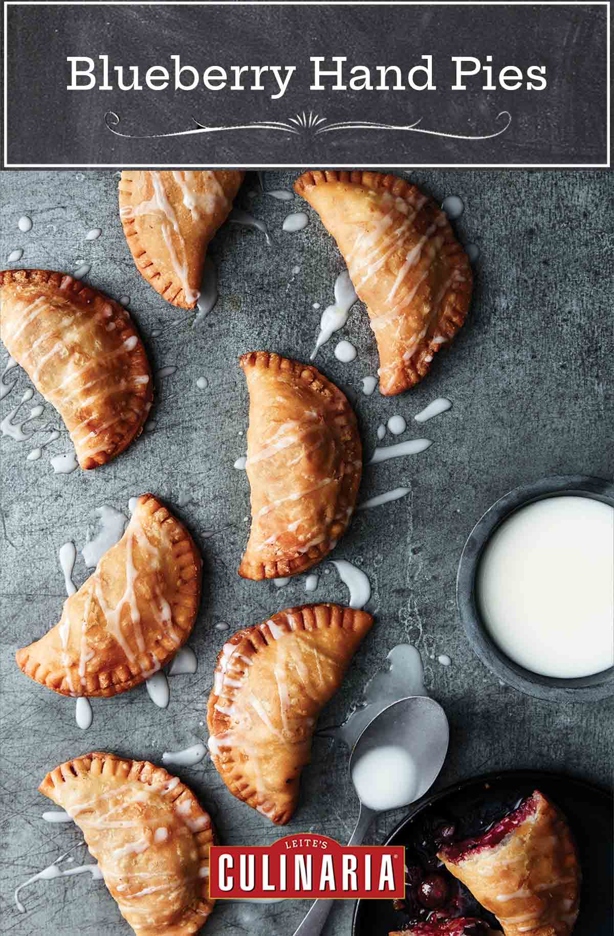 8 crescent-shape blueberry fried pies with Meyer lemon drizzle sauce nearby all on a piece of slate