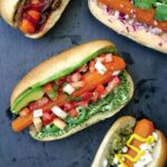 Four carrot hot dogs filled with assorted garnishes.