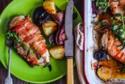 A green plate topped with a chicken breast stuffed with fresh figs and goat cheese and some roasted root vegetables alongside.