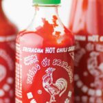 Tre flaskor fyllda med hemgjord Srirachasås.