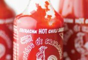Three bottles filled with homemade Sriracha sauce.