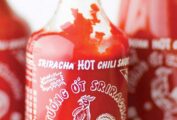 Three bottles filled with homemade Sriracha sauce.