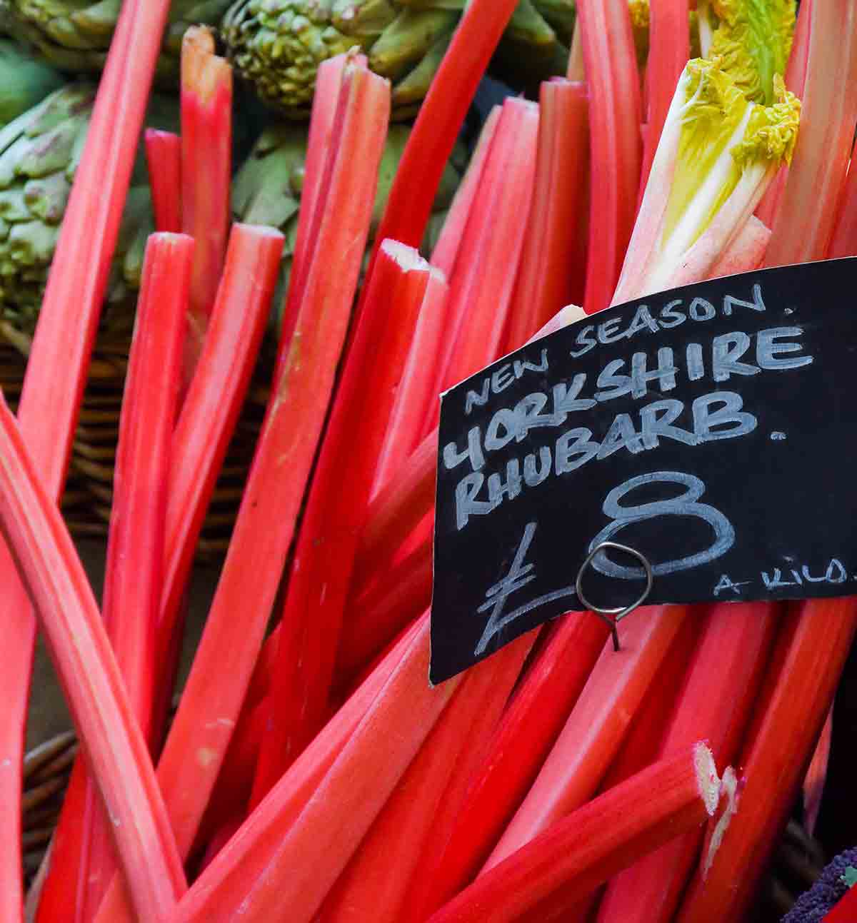 Stalks of rhubarb with a black price sign.