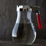A syrup canister half-filled with simple syrup.
