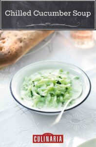 A bowl of chilled cucumber soup with a spoon resting inside.