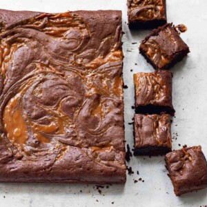 A slab of dulce de leche brownies, with five brownies cut from the end.