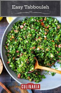 A bowl of tabbouleh with a wooden spoon resting inside.