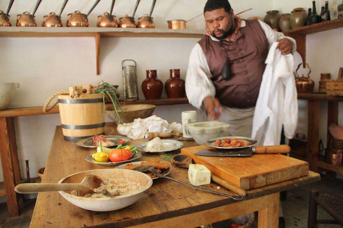 Michael Twitty in historical costume in a plantation kitchen.