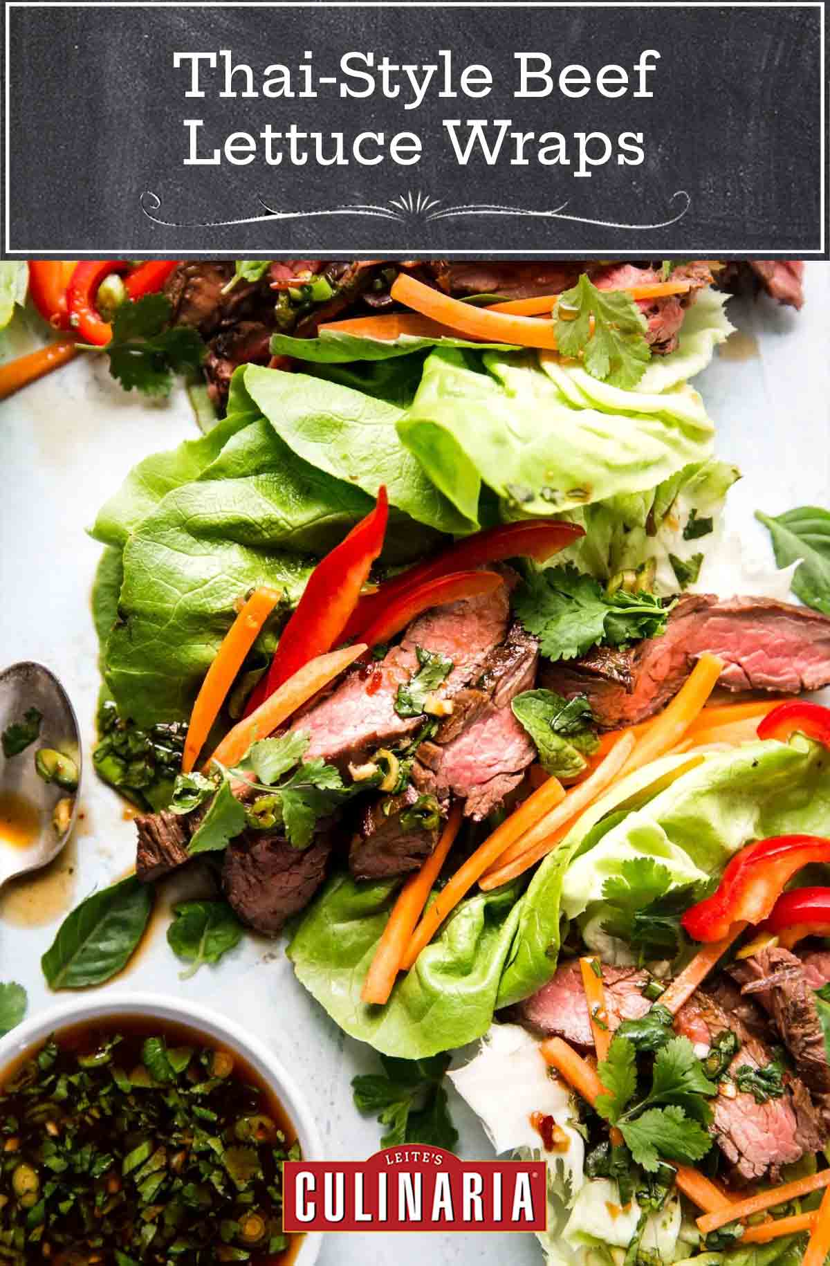 Three assembled Thai-style sliced beef lettuce wraps with a bowl of dipping sauce on the side.