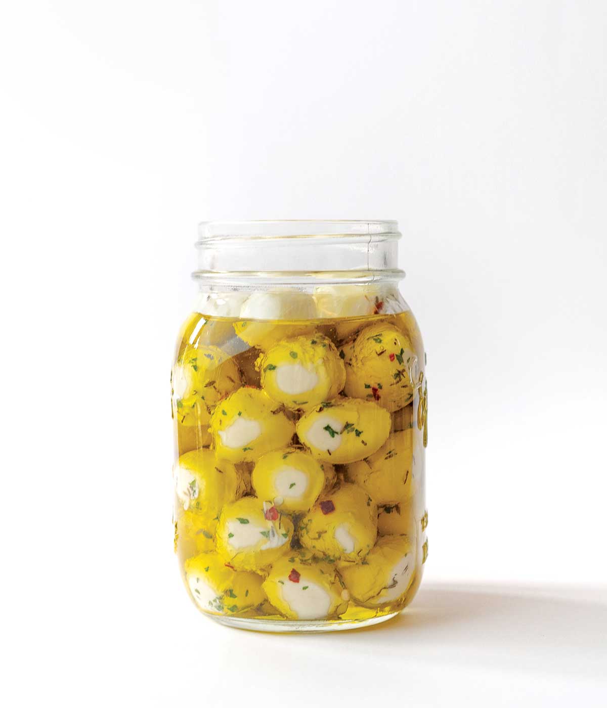 A jar of Armenian yogurt cheese balls in oil.