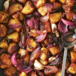 A roasting pan filled with balsamic roasted potatoes and red onions and garlic