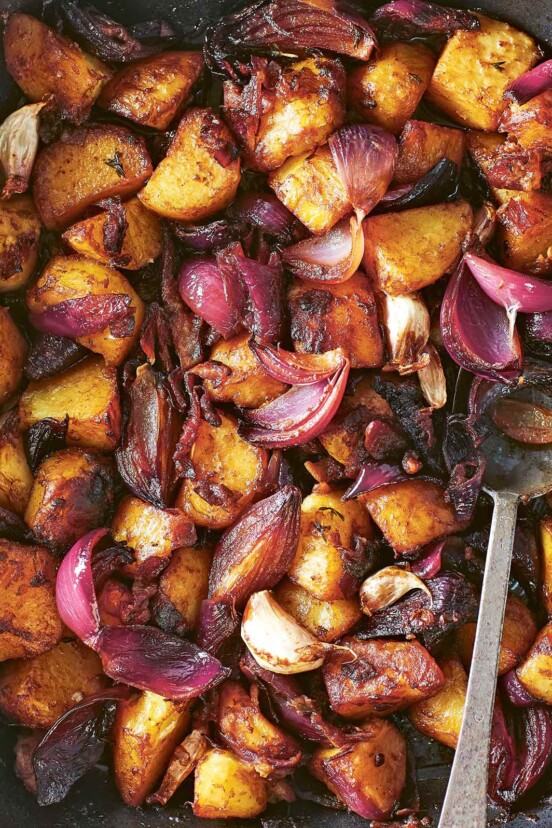 A roasting pan filled with balsamic roasted potatoes and red onions and garlic