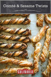 Various filled puff pastry twists lying on a sheet of parchment paper.