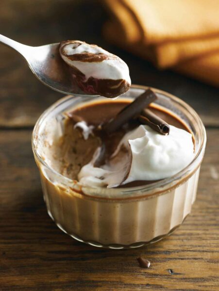 A spoon lifting a scoop of dessert from a double chocolate pots de crème.