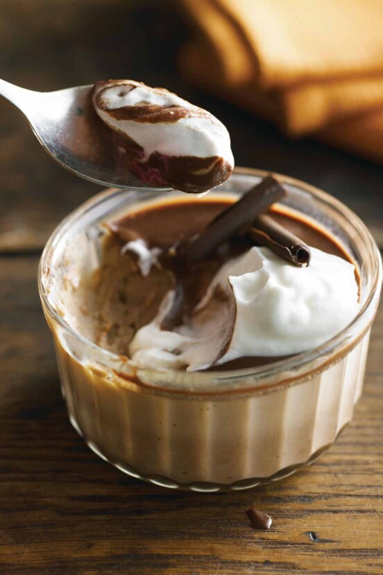A spoon lifting a scoop of dessert from a double chocolate pots de crème.