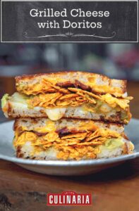 A gray plate with a grilled cheese with Doritos, bacon, and guacamole.