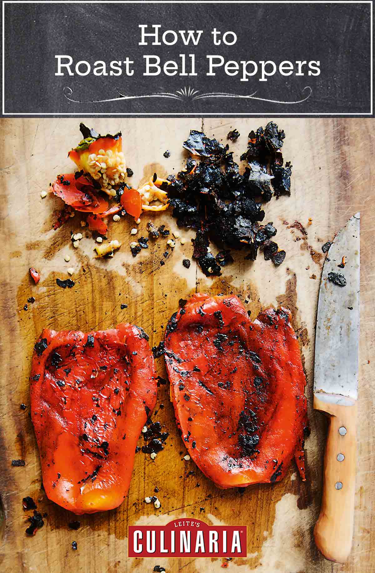 2 roasted red peppers on a cutting board with a large knife, and scraps of charred pepper skin.