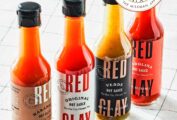 A line up of four bottles of Red Clay Hot Sauce--Habanero, Original, Verde, and Carolina