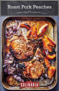 A rimmed sheet pan with roast pork chops with peaches and cooked red onion.