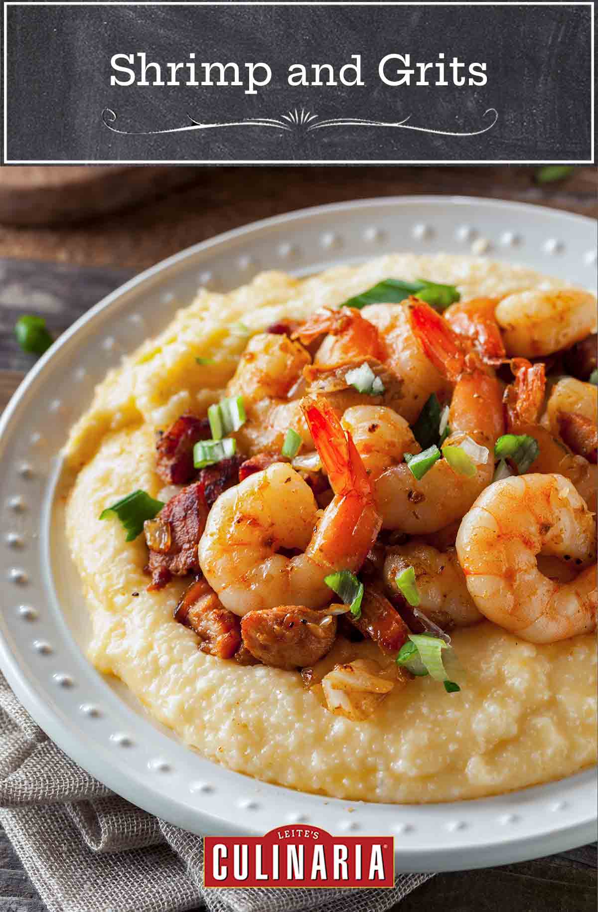 A white plate filled with cheesy shrimp and grits with bacon
