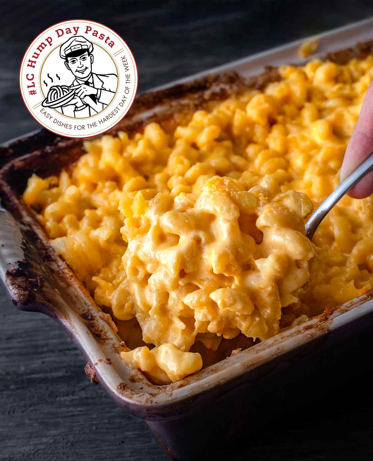 A close-up of a casserole dish filled with macaroni and cheese, with a large spoonful being lifted out.